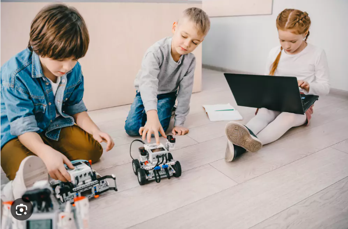 3 kids with robot and laptop